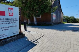 Tablica informacyjna o modernizacji ulicy Romualda Minkiewicza w Filipowie, dofinansowanej z programu rządowego