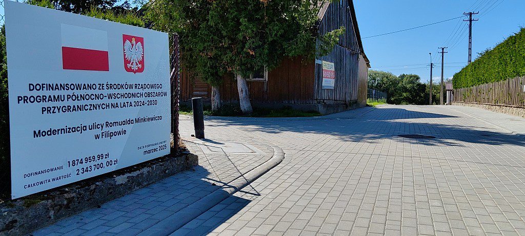 Tablica informacyjna o modernizacji ulicy Romualda Minkiewicza w Filipowie, dofinansowanej z programu rządowego