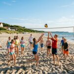 Grupa dzieci grająca w siatkówkę plażową na piasku przy ośrodku Baltic Dunes Resort