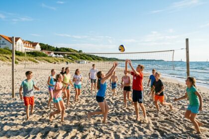 Grupa dzieci grająca w siatkówkę plażową na piasku przy ośrodku Baltic Dunes Resort