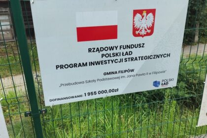 Tablica informacyjna o dofinansowaniu 1 955 000 zł z Polskiego Ładu na przebudowę szkoły podstawowej w Filipowie