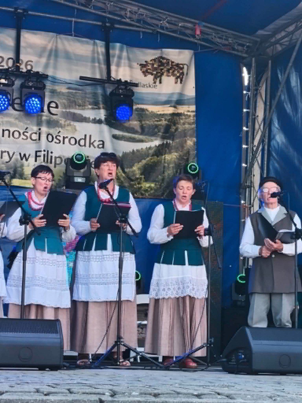 Występ zespołu ludowego w tradycyjnych strojach na scenie plenerowej w Filipowie