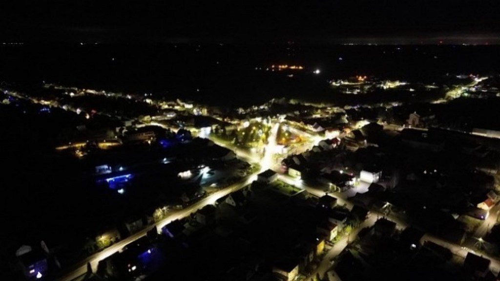 Nocna panorama miejscowości z lotu ptaka z oświetlonymi ulicami i budynkami