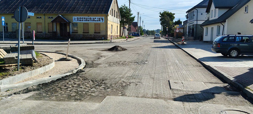 Ulica w trakcie remontu z wyfrezowanym asfaltem i odsłoniętym brukiem