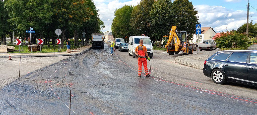 Robotnicy drogowi i sprzęt budowlany podczas prac remontowych na ulicy